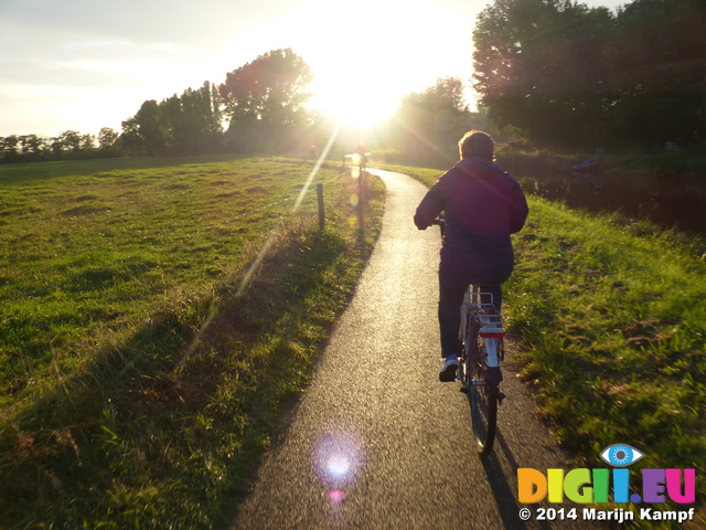 FZ008499 Hans, Machteld and Jenni push biking into sunset